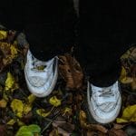 Man Wearing White Sneakers in a Forest