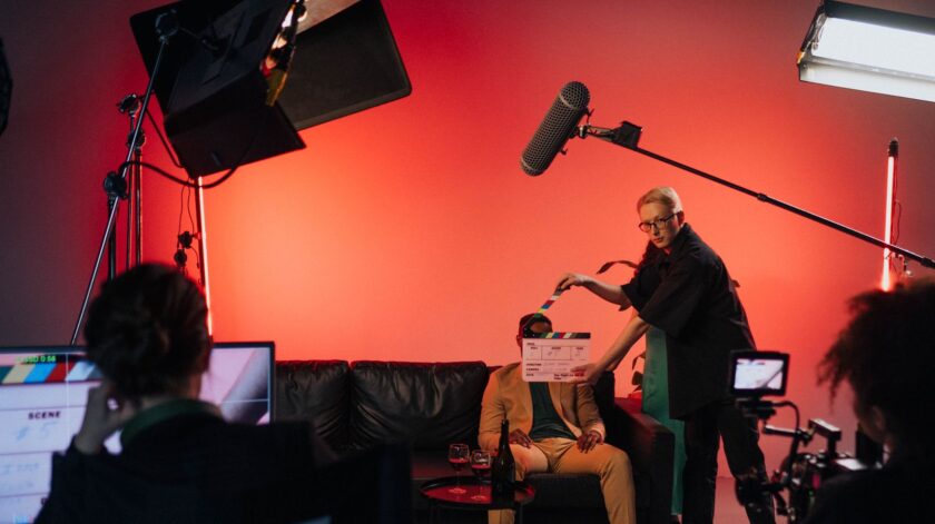 a person in black shirt holding a clapperboard during the filming
